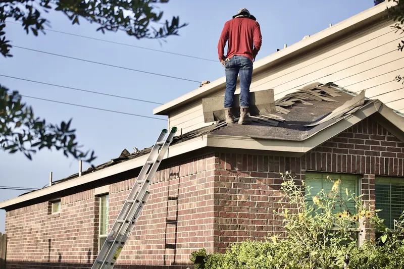 Professional roofer working on a residential roof in Kenneys
